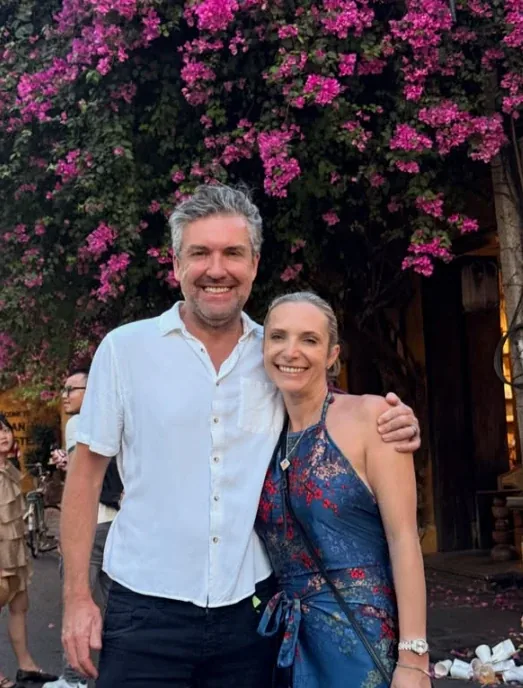 Smiling couple under bougainvillea on a Dental Destinations trip
