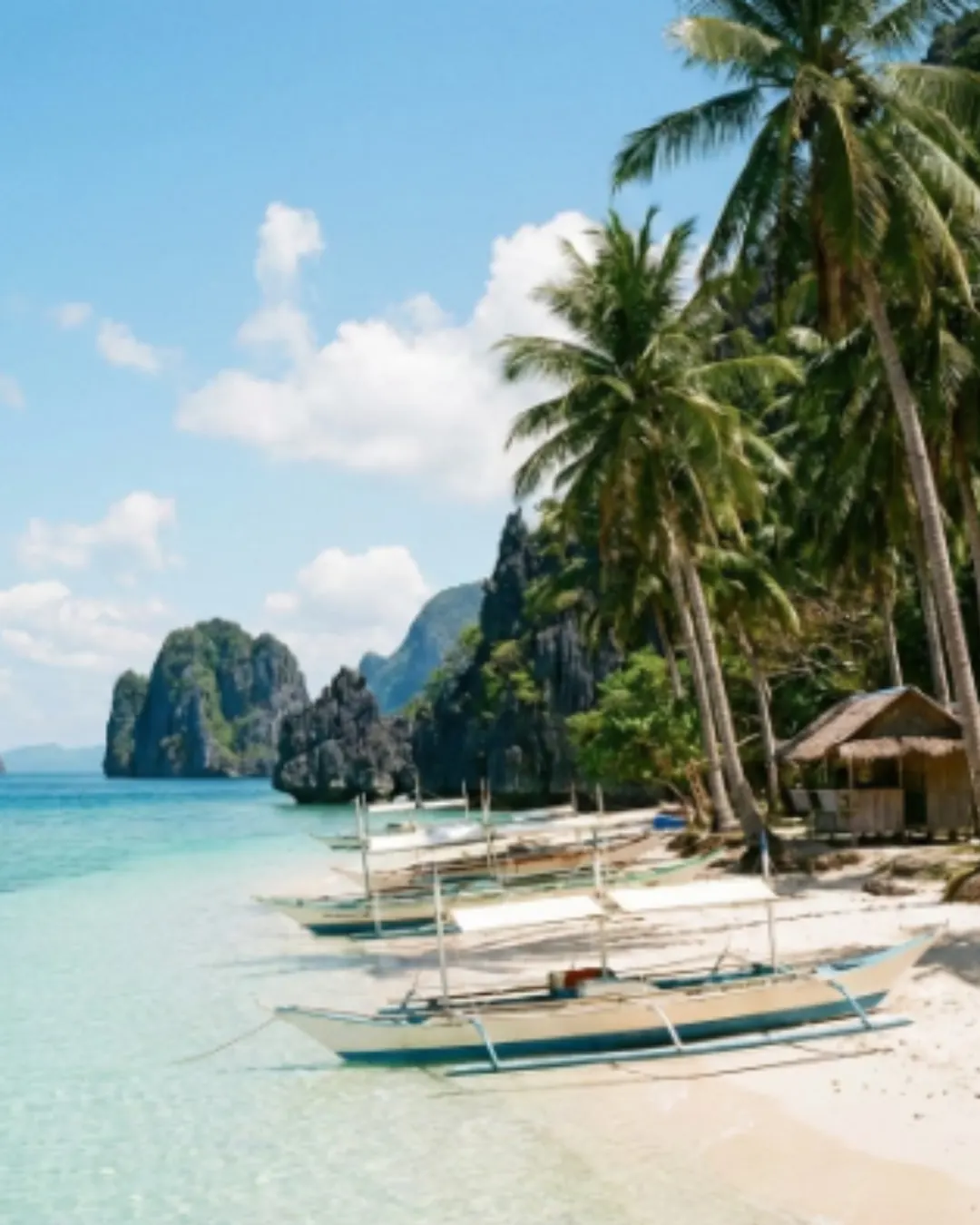 Outrigger boats on a white sand beach in the Philippines